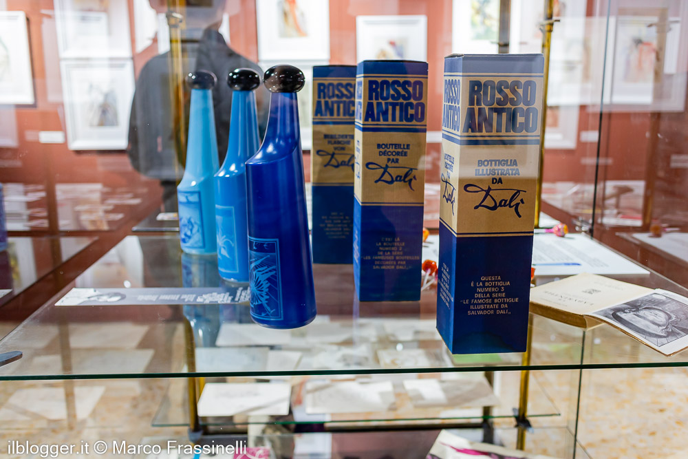 Bottiglie e confezioni Rosso Antico illustrate da Salvador Dalí, esposte nella sezione dedicata al rapporto tra arte, pubblicità e immagine dell’artista